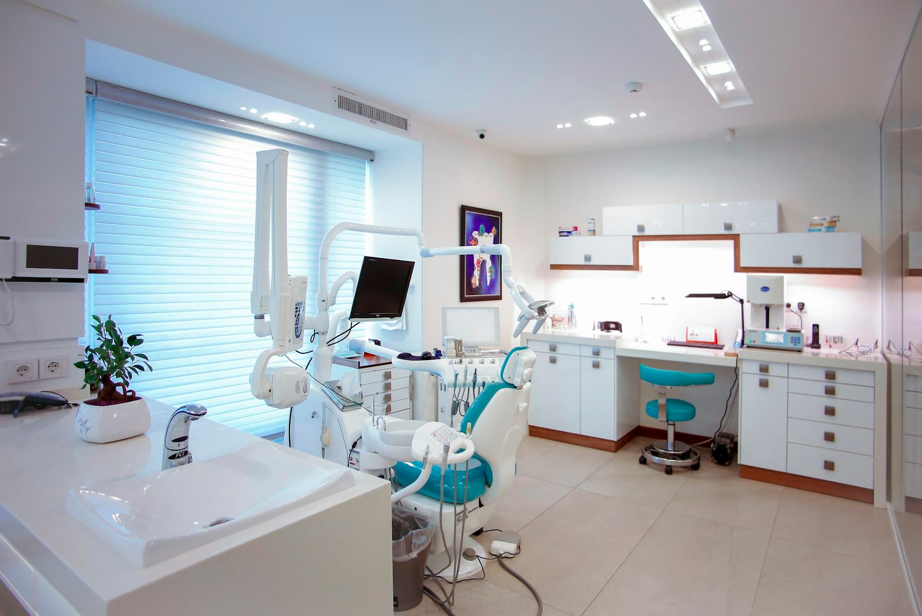Bright, clean dental treatment room with a patient chair and cabinetry