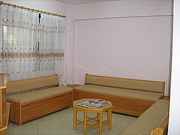 Waiting area with cushioned wooden benches and a small table